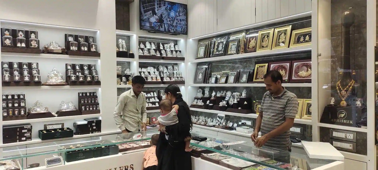 Silver price today के बीच सर्राफा बाजार की चांदी दुकान में ग्राहक और स्टाफ चांदी के आभूषण दिखाते हुए